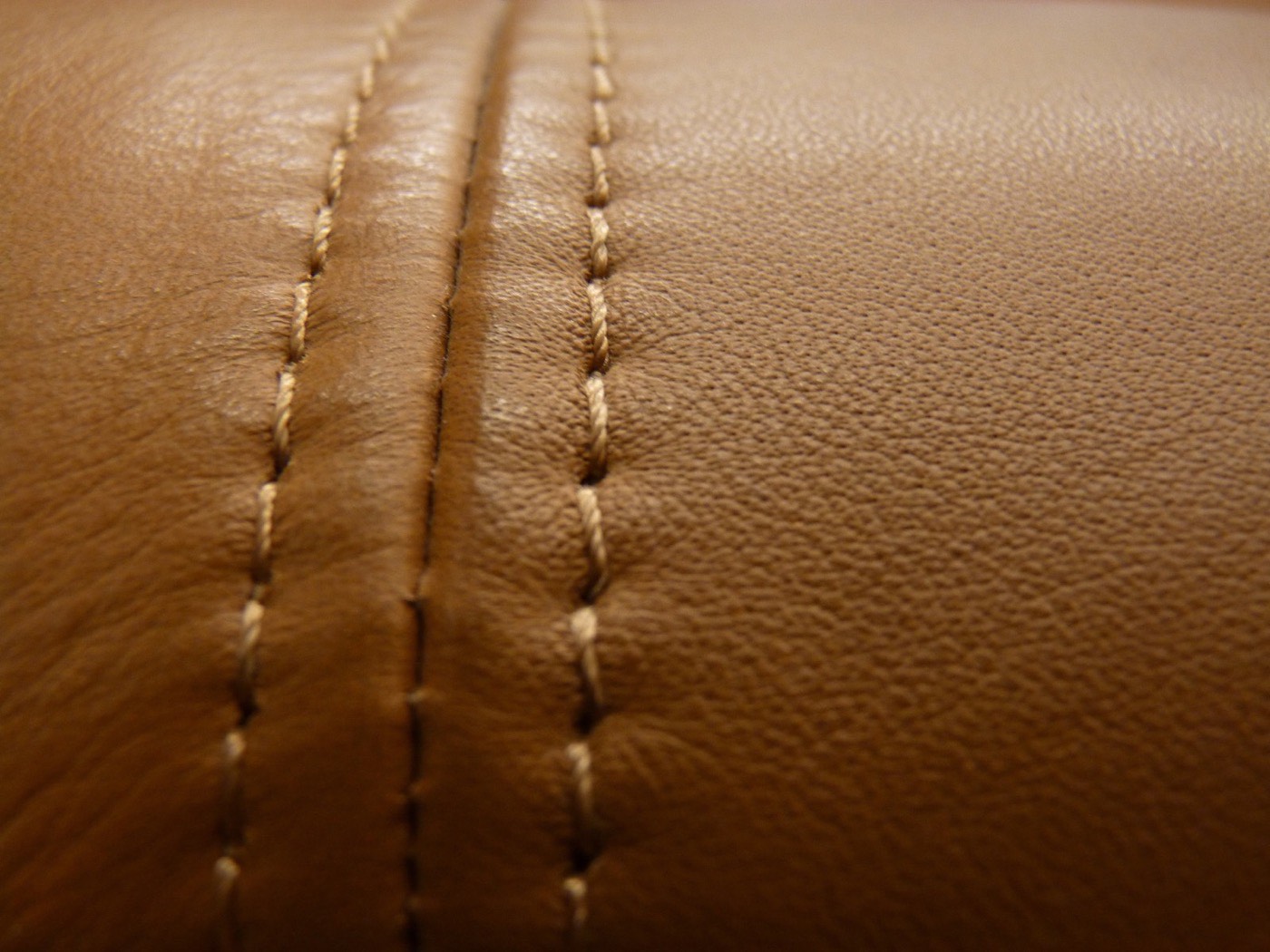 Close-up of a leather sofa stitched with brown thread